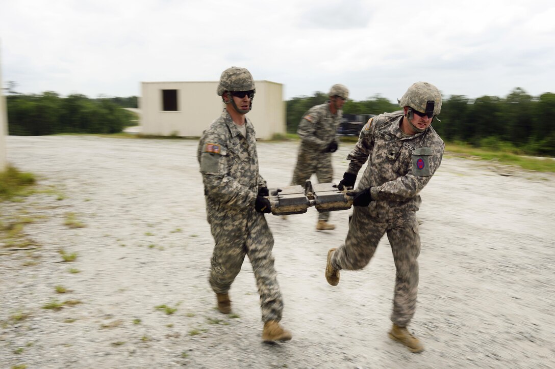 Army Pfc. Phillip Hill, left, and Spc. Brandon Sinor run with a replacement section of track to be installed on an M1A2 Abrams tank during the Gen. Gordon Sullivan Cup best tank crew competition at Fort Benning, Ga., May 2, 2016. Hill and Sinor are assigned to the North Carolina Army National Guard’s Company C, 1st Battalion, 252nd Armor Regiment. Army photo by Sgt. 1st Class Jon Soucy