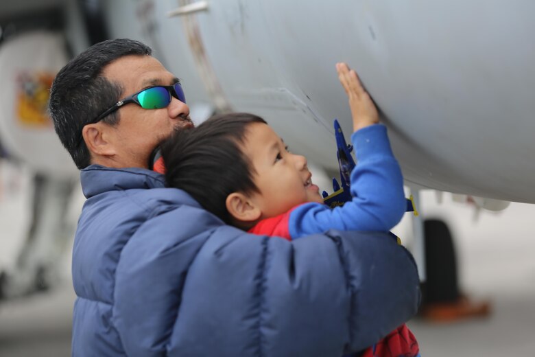 A father hoists his son to touch the side of an aircraft at the 2016 Marine Corps Air Station Cherry Point Air Show – “Celebrating 75 Years” at MCAS Cherry Point, N.C., April 30, 2016. This year’s air show celebrated MCAS Cherry Point and 2nd Marine Aircraft Wing’s 75th anniversaries and featured 40 static displays, 17 aerial performers and a concert. (U.S. Marine Corps photo by Lance Cpl. Mackenzie Gibson/ Released)