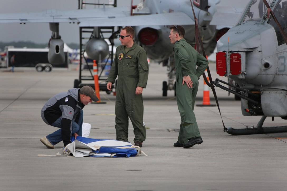 Marines, Sailors and civilians disassemble set-ups on the flight line following the 2016 Marine Corps Air Station Cherry Point Air Show -- "Celebrating 75 Years' at MCAS Cherry Point, N.C. The air show celebrated MCAS Cherry Point and 2nd Marine Aircraft Wing’s 75th anniversaries and featured 40 static displays, 17 aerial performers and a concert.