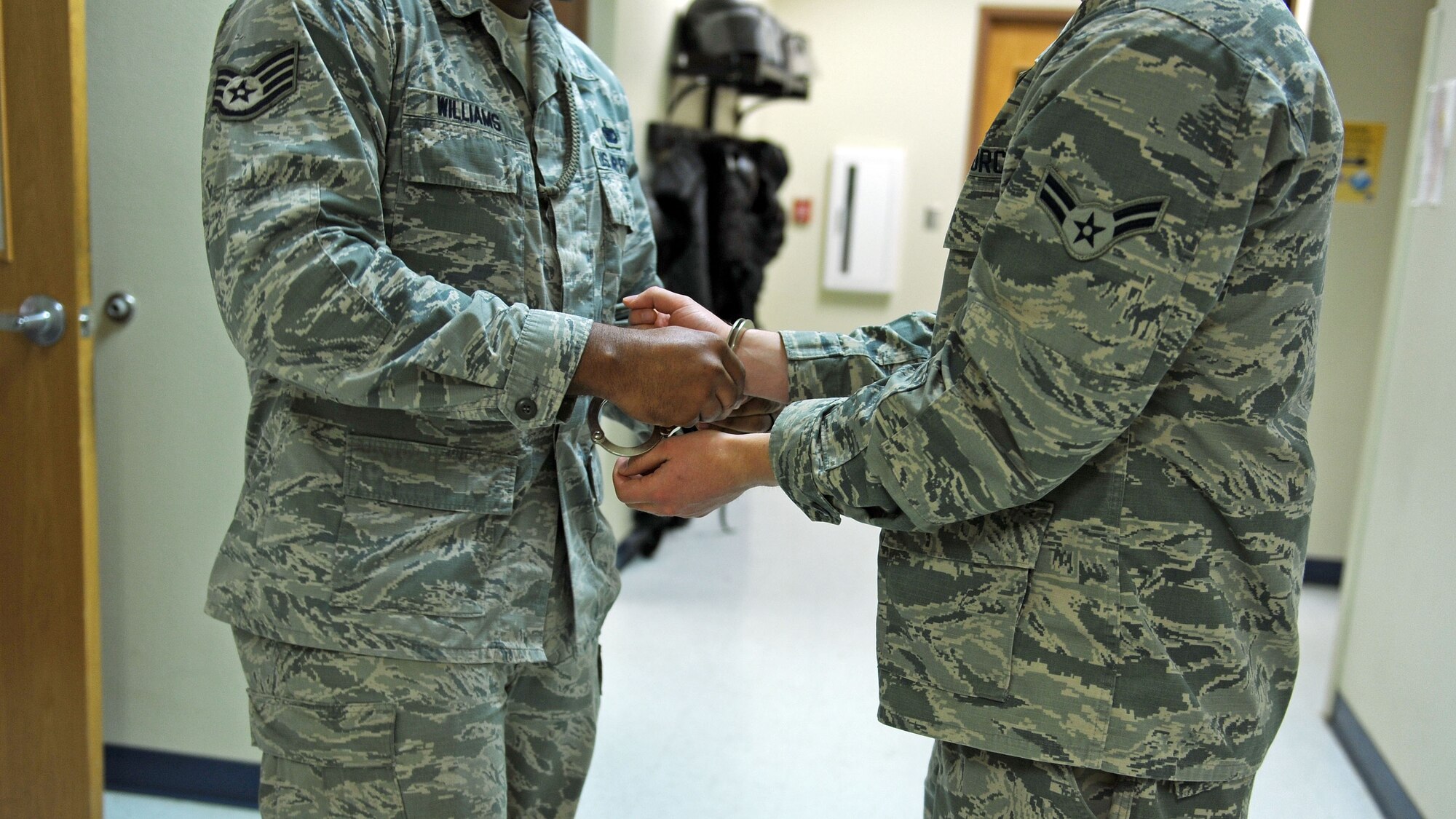 Staff Sgt. Ali Williams, 27th Special Operations Security Forces Squadron confinement NCO in-charge, simulates handcuffing an inmate at the 27th SOSFS compound April 13, 2016, at Cannon Air Force Base, N.M. When convicted of a court martial for infractions against the punitive articles of the Uniform Code of Military Justice or when placed in pre-trial confinement, members are transported to the confinement section until their sentence is served or they are found innocent of charges. (U.S. Air Force photo/Staff Sgt. Whitney Amstutz)