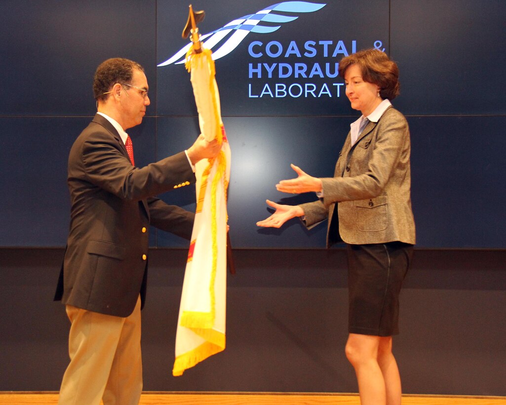 Jose Sanchez, director of the Coastal and Hydraulics Laboratory, U.S. Army Engineer Research and Development Center, presents the Scientific and Professional flag to Dr. Jane McKee Smith.  Smith began her distinguished career with ERDC in 1983.