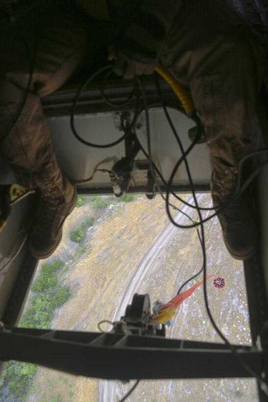 Cpl. Aaron Culler, a crew chief with Marine Medium Tiltrotor Squadron (VMM) 165, observes the Bambi bucket below an MV-22B Osprey and waits for the bucket to fill with water during the 2016 Wildland Firefighting Exercise aboard Marine Corps Base Camp Pendleton, Calif., May 5. The exercise was a multiaircraft operation with both ground and air units working together for maximum firefighting efforts.  (U.S. Marine Corps photo by Lance Cpl. Harley Robinson/Released)