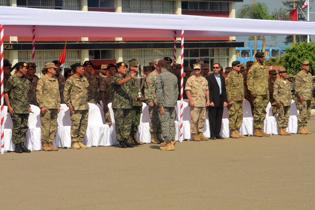 A special operations soldier hands a trophy to a Peruvian military leader as U.S. and foreign special operations teams participate in the opening ceremony of Fuerzas Comando 2016 in Ancon, Peru, May 2, 2016. Fuerzas Comando 2016 is a U.S. Southern Command-sponsored exercise that allows countries to train through friendly competition while promoting military-to-military relationships. Army photo by Sgt. Eric Roberts