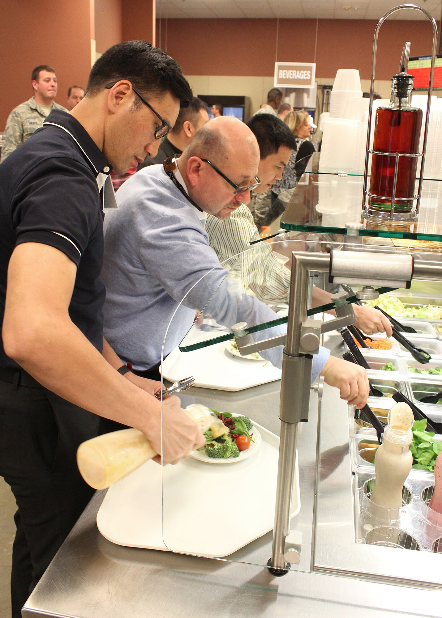 From left, Fathers John Tran, Gustov Montanez and Dwong Nguyen visit the salad bar in the base dining facility at Creech Air Force Base, Nev. The civilian Catholic priests got a first-hand look at the Air Force chaplain way of life as part of the recent Air Force Recruiting Service’s “Come Be With Us Familiarization Tour” of Creech and Nellis AFB, Nev. (U.S. Air Force photo/Dale Eckroth)