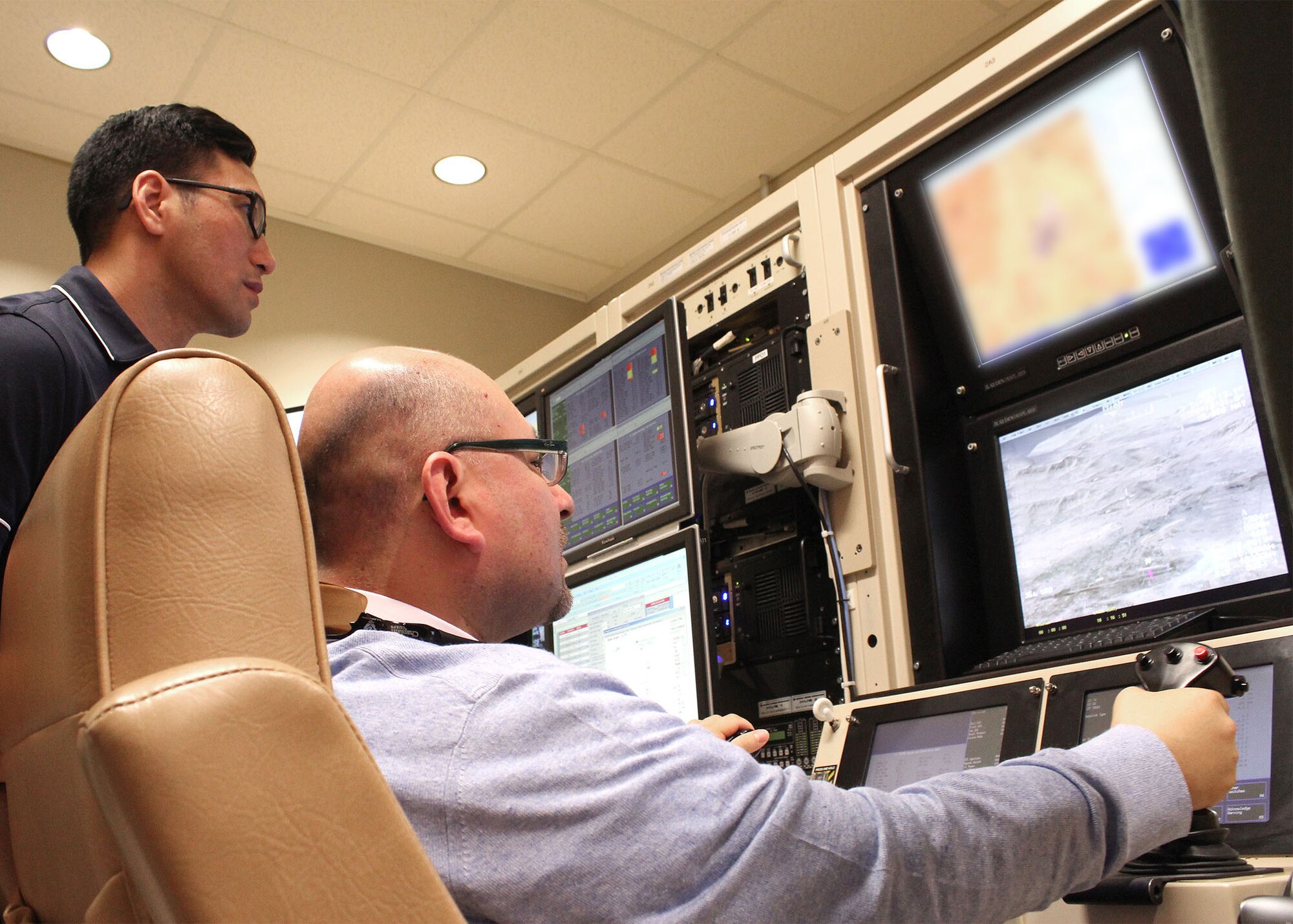 Father Gustav Montanez tries his hand at flying a remotely piloted aircraft in the RPA simulator at Creech Air Force Base, Nev. Montanez was among six civilian Catholic priests who participated in the recent Air Force Recruiting Service’s “Come Be With Us Familiarization Tour” at Creech and Nellis AFB, Nev. The priests got a first-hand look at the Air Force chaplain way of life. (U.S. Air Force photo/Dale Eckroth)