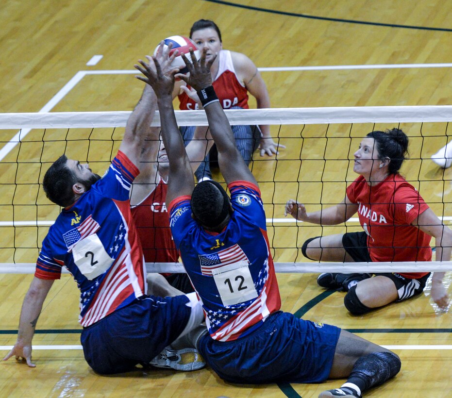 Retired Air Force Staff Sgt. Nicholas Dadgostar and retired Army Staff Sgt. Alexander Shaw, members of the U.S. team, block a spike in a preliminary sitting volleyball game against the Canadian team at the 2016 Invictus Games in Orlando, Fla., May 7, 2016. Air Force photo by Senior Master Sgt. Kevin Wallace