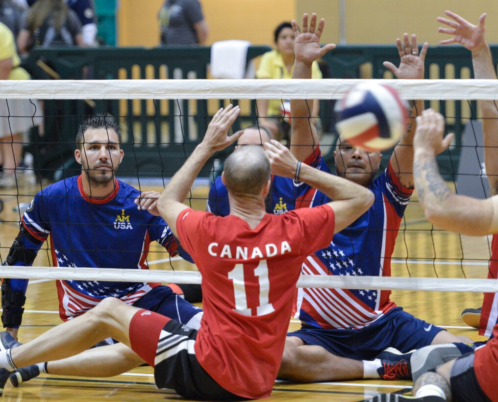 Retired Army Sgt. Robbie Gaupp, left, and Army Sgt. 1st Class Alfred Martinez, members of the U.S. team, watch as Canadian athletes attempt to block a serve in a sitting volleyball match at the 2016 Invictus Games in Orlando, Fla., May 7, 2016. Air Force photo by Senior Master Sgt. Kevin Wallace