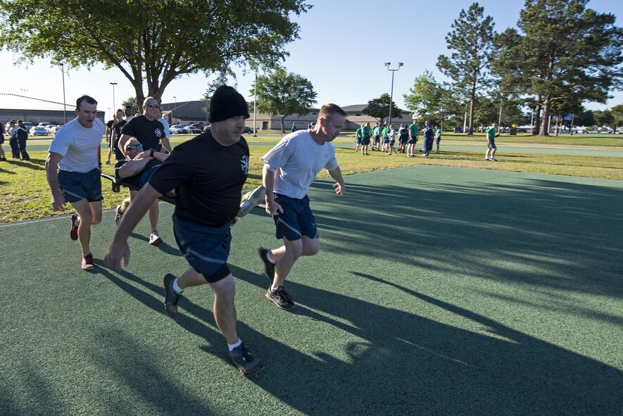 U.S. Air Force Airmen perform a litter carry, May 6, 2016, at Moody Air Force Base, Ga. The Airmen split into teams of five to run across an exercise pad and swap out a member of the team until all team members were carried. U.S. Air Force(U.S. Air Force photo by Airman 1st Class Janiqua P. Robinson/Released)