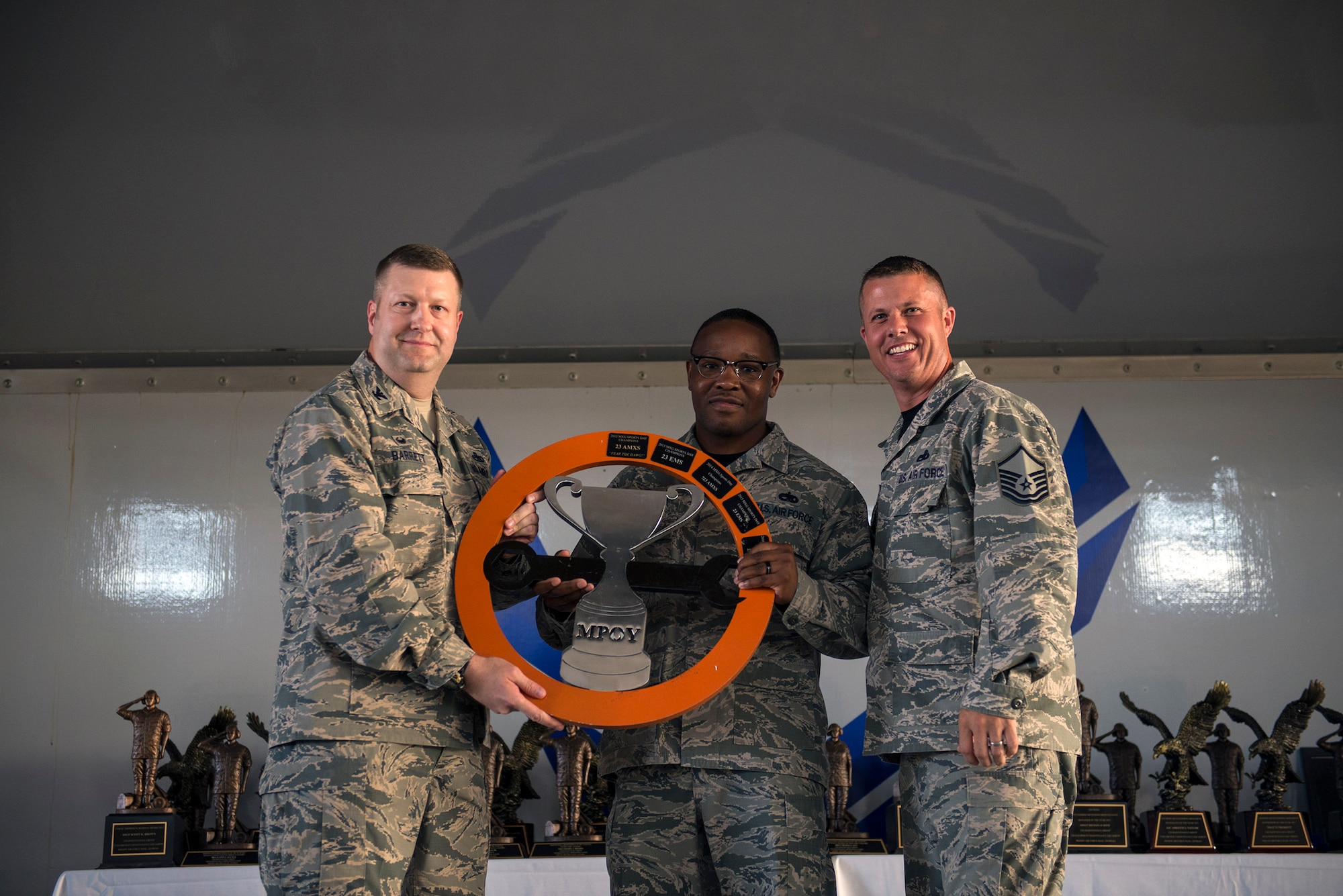 U.S. Air Force Col. Shane Barrett, 23d Maintenance Group commander, left, presents Tech. Sgt. Albert Turner, 23d Maintenance Operations Flight wing plans, scheduling 
and documentation center assistant section chief, and Master Sgt. Scott Mixon, Maintenance Operations Control center section chief, with the 2016 MXG Super Sports day championship trophy during the 2016 Maintenance Professional of the Year awards banquet, May 6, 2016, at Moody Air Force Base, Ga. The 23d MOF came out victorious after competing in events such as the relay race, obstacle course and litter carry. (U.S. Air Force photo by Airman 1st Class Greg Nash/Released) 
