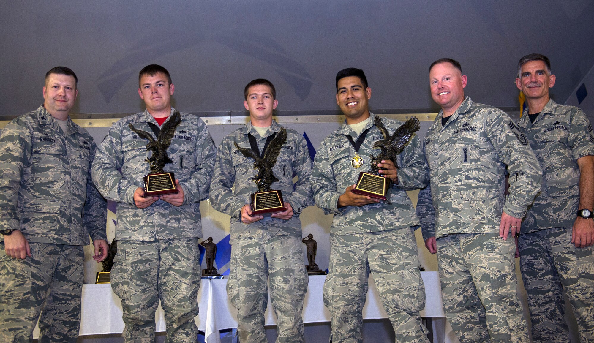 U.S. Air Force Col. Shane Barrett, 23d Maintenance Group commander, left, and Chief Master Sgt. John Brinkley, 23d Maintenance Group chief enlisted manager, right, presents the A-10C Thunderbolt II Load Crew of the Year trophies to members of the 75th Aircraft Maintenance Unit during the 2016 Maintenance Professional of the Year awards banquet, May 6, 2016, at Moody Air Force Base, Ga. These aircraft armament systems specialists are responsible for loading, unloading and positioning munitions on the A-10C Thunderbolt II. (U.S. Air Force photo by Airman 1st Class Greg Nash/Released)  