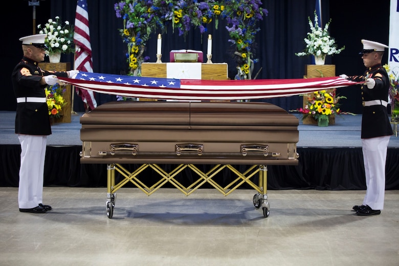 Marines with 4th Law Enforcement Battalion, Force Headquarters Group, Marine Forces Reserve, begin to fold the flag that draped the casket of Conrad Burns, former U.S. Senator, during the memorial service at MetraPark’s Rimrock Auto Arena, May 6, 2016. The ceremonial folding and presentation of the flag is a tribute to the veteran's family. Burns served in the Marine Corps from 1955-1957 and also served as a U.S. Senator from 1989- 2007. Marine Forces Reserve performed 91 percent of all funeral honors rendered by the Marine Corps in calendar year 2015 and continues to provide timely and professional support to veterans.  (U.S. Marine Corps photo by Lance Cpl. Melissa Martens/ Released)  