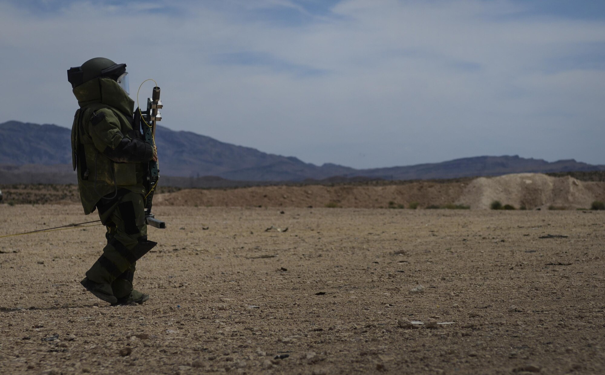 Staff Sgt. Jeffery Glover, 99th Civil Engineer Squadron explosive ordinance technician, carries a tool to break the back window of a vehicle that has a simulated vehicle born improvised explosive device as a part of a training exercise at Nellis Air Force Base, Nev., May 5, 2016. The tool uses a shotgun shell as a projectile in order to break the back window of a vehicle and gain access to the VBIED. (U.S. Air Force photo by Airman 1st Class Kevin Tanenbaum)