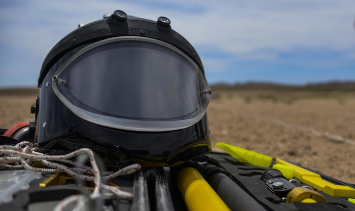 An explosive ordinance helmet sits on a tool kit during a training exercise at Nellis Air Force Base, Nev. May 5, 2016. The helmet is part of an EOD suit that is a heavy suit of body armor designed to withstand the pressure generated by a bomb and any fragments the bomb may produce. (U.S. Air Force photo by Airman 1st Class Kevin Tanenbaum)