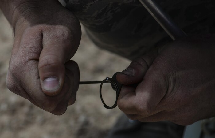 Senior Airman Kyle Osgood, 99th Civil Engineer Squadron explosive ordinance technician, pulls the pin on an explosive during a training exercise at Nellis Air Force Base, Nev., May 5, 2016. EOD technicians provide the ability to detect, monitor, evaluate, and decontaminate explosive, radioactive, chemical, or biological ordnance hazards. (U.S. Air Force photo by Airman 1st Class Kevin Tanenbaum)
