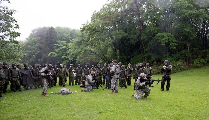 CAMP ZAMA, Japan (April 28, 2016) -  MEDDAC-Japan Soldiers and Japan Ground Self-Defense Force members provide security while another member administers aid to a mock casualty during the bi-lateral tactical combat casualty care training at Camp Zama's Dewey Park. 