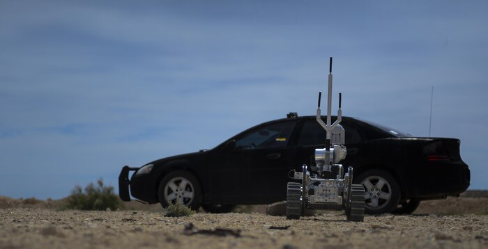 An explosive ordinance robot moves towards a car to check for a simulated vehicle born improvised explosive device during a training exercise at Nellis Air Force Base, Nev., May 5, 2016. The Robot has a camera attached to the arm so as to allow the EOD technician a better look at the site without being in a close proximity to the explosive. (U.S. Air Force photo by Airman 1st Class Kevin Tanenbaum)