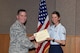 U.S. Air Force Col. Michael Grunwald Jr., 17th Training Group Commander, presents the 316th Training Squadron Student of the Month award for April 2016 to Airman Heather Cannon in Brandenburg Hall on Goodfellow Air Force Base, Texas, May 6, 2016. (U.S. Air Force photo by Staff Sgt. Laura R. McFarlane/Released)