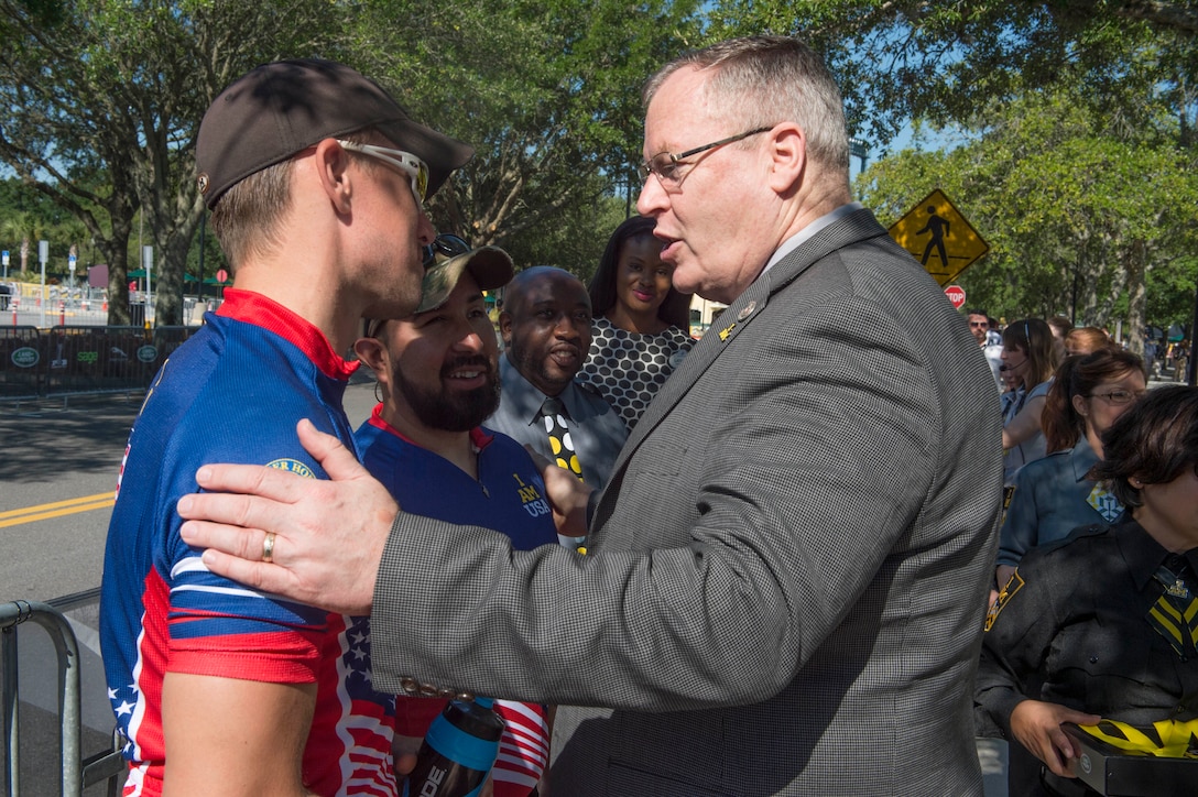 Deputy Defense Secretary Bob Work speaks to a Team USA cyclist at the 2016 Invictus Games in Orlando, Fla., May 9, 2016. DoD photo by Navy Petty Officer 1st Class Tim D. Godbee