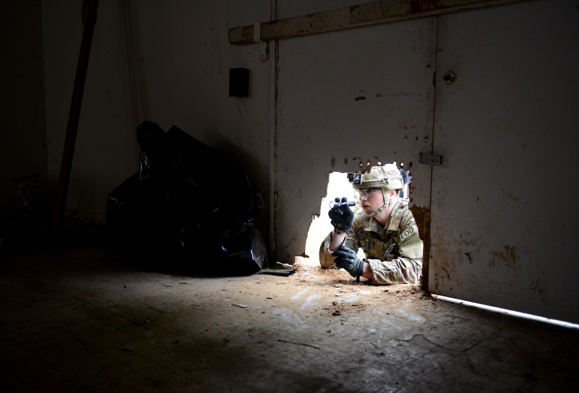 Airman 1st Class Alex Nona, 60th Civil Engineer Squadron explosive ordnance disposal technician, inspects the interior of an abandoned structure known as the “bomb factory” prior to entry during an exercise May 5th, 2016, at Clear Lake, California. Nona and other EOD technicians were tasked to eliminate numerous improvised explosive devices and a radioactive dispersal device within the abandoned structure. (U.S. Air Force photo by Senior Airman Bobby Cummings)