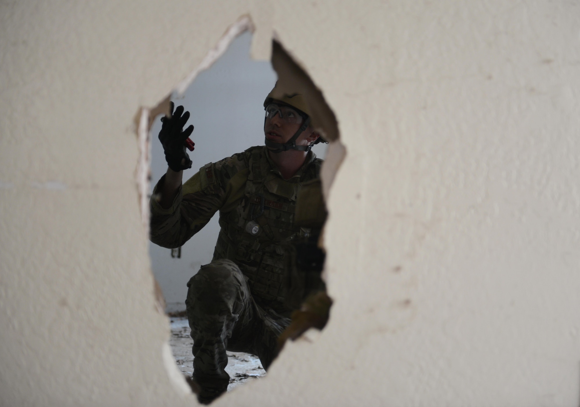 Staff Sgt. David Dezwaan, 60th Civil Engineer Squadron explosive ordnance disposal technician, attempts to enter a room with multiple booby-trap simulated improvised explosive devices May 5th, 2016, at Clear Lake, California. Dezwaan, and other EOD technicians were tasked to eliminate numerous improvised explosive devices and a radioactive dispersal device within the abandoned structure. (U.S. Air Force photo by Senior Airman Bobby Cummings)