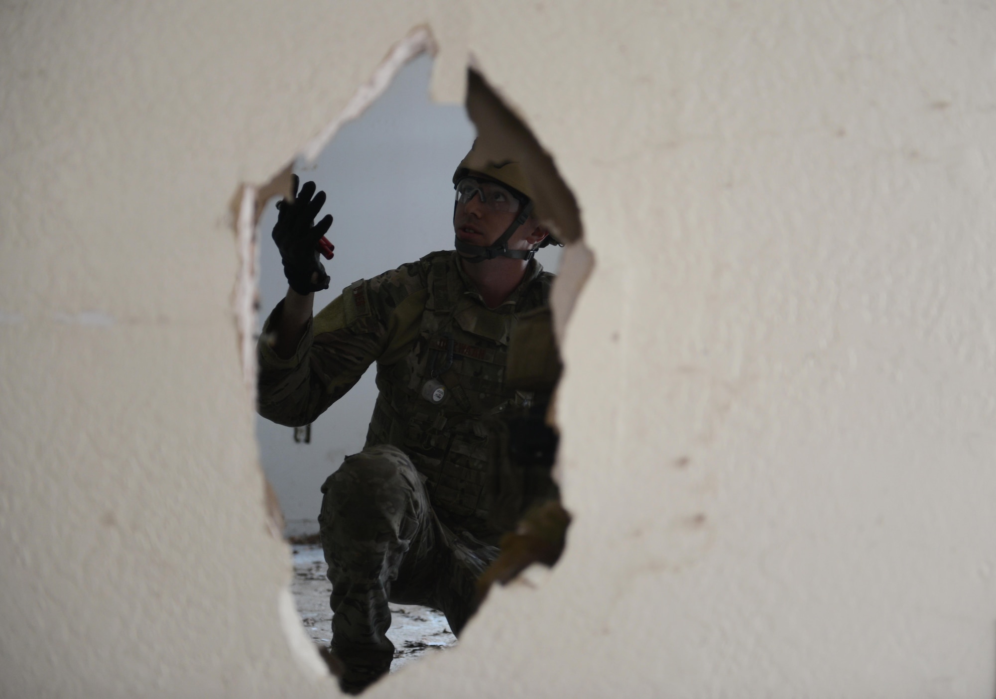 Staff Sgt. David Dezwaan, 60th Civil Engineer Squadron explosive ordnance disposal technician, attempts to enter a room with multiple booby-trap simulated improvised explosive devices May 5th, 2016, at Clear Lake, California. Dezwaan, and other EOD technicians were tasked to eliminate numerous improvised explosive devices and a radioactive dispersal device within the abandoned structure. (U.S. Air Force photo by Senior Airman Bobby Cummings)