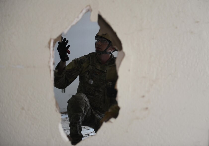 Staff Sgt. David Dezwaan, 60th Civil Engineer Squadron explosive ordnance disposal technician, attempts to enter a room with multiple booby-trap simulated improvised explosive devices May 5th, 2016, at Clear Lake, California. Dezwaan, and other EOD technicians were tasked to eliminate numerous improvised explosive devices and a radioactive dispersal device within the abandoned structure. (U.S. Air Force photo by Senior Airman Bobby Cummings)