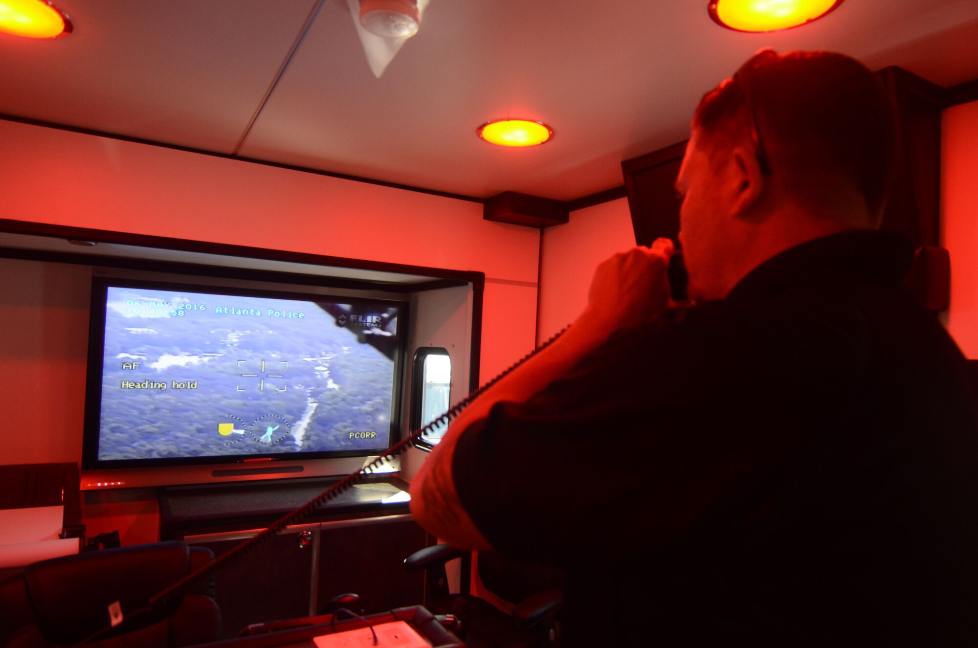 A member of the Atlanta Police Department communicates with an APD helicopter as it scans local terrain during the 2016 Statewide Mobile Communication Vehicle (MVC) Functional Field Exercise (FFX) held at Stone Mountain State Park, Stone Mountain, Ga. May 2-6, 2016. The exercise presents a series of catastrophe type scenarios testing critical communication and coordination between MCV emergency response agencies from around the State of Georgia. (U.S. Air Force photo/Don Peek)