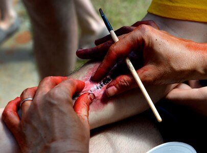 U.S. Air Force Master Sgt. Caroline Bunce, 628th Aerospace Medical Squadron dental hygienist, applies moulage to victim role player during the 2016 LowCountry Skills Fair, May 4, 2016, at Joint Base Charleston - Naval Weapons Station, S.C. Bunce applied moulage to volunteers to simulate real-world injuries for competitors to practice on during the skills Olympics. (U.S. Air Force photo by Staff Sgt. Michael Battles)