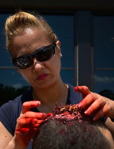 U.S. Air Force Master Sgt. Caroline Bunce, 628th Aerospace Medical Squadron dental hygienist, applies moulage to victim role player during the 2016 LowCountry Skills Fair, May 4, 2016, at Joint Base Charleston - Naval Weapons Station, S.C. Bunce applied moulage to volunteers to simulate real-world injuries for competitors to practice on during the skills Olympics. (U.S. Air Force photo by Staff Sgt. Michael Battles)