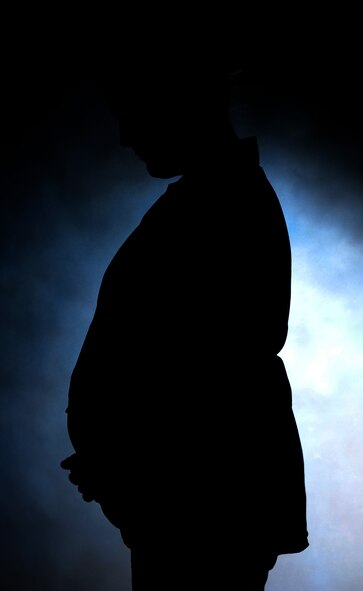 Airman Jessica Pasch, 341st Force Support Squadron administrative assistant, holding her stomach at Malmstrom Air Force Base, Mont., May 5, 2016. As she reflects on the challenges and joys of what it means to be a mother in the military. (U.S. Air Force photo/Senior Airman Jaeda Tookes) 