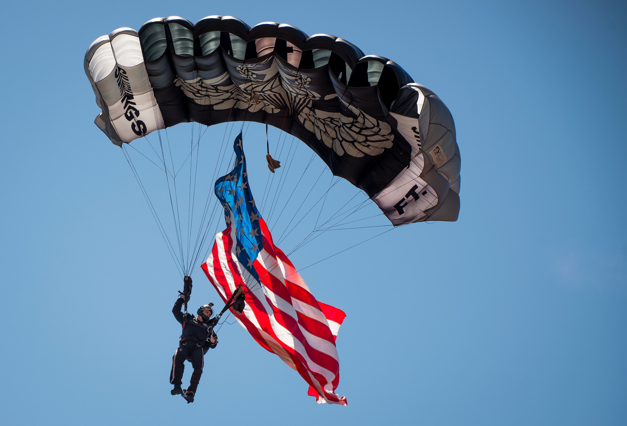 The lead Silver Wings ski-diver vectors in for a landing carrying a giant American flag during the 6th Ranger Training Battalion’s open house event May 7 at Eglin Air Force Base, Fla.  The event was a chance for the public to learn how Rangers train and operate. The event displays showed equipment, weapons, a reptile zoo, face painting and weapon firing among others. The demonstrations showed off hand-to-hand combat, a parachute jump, snake show, and Rangers in action. (U.S. Air Force photo/Samuel King Jr.)