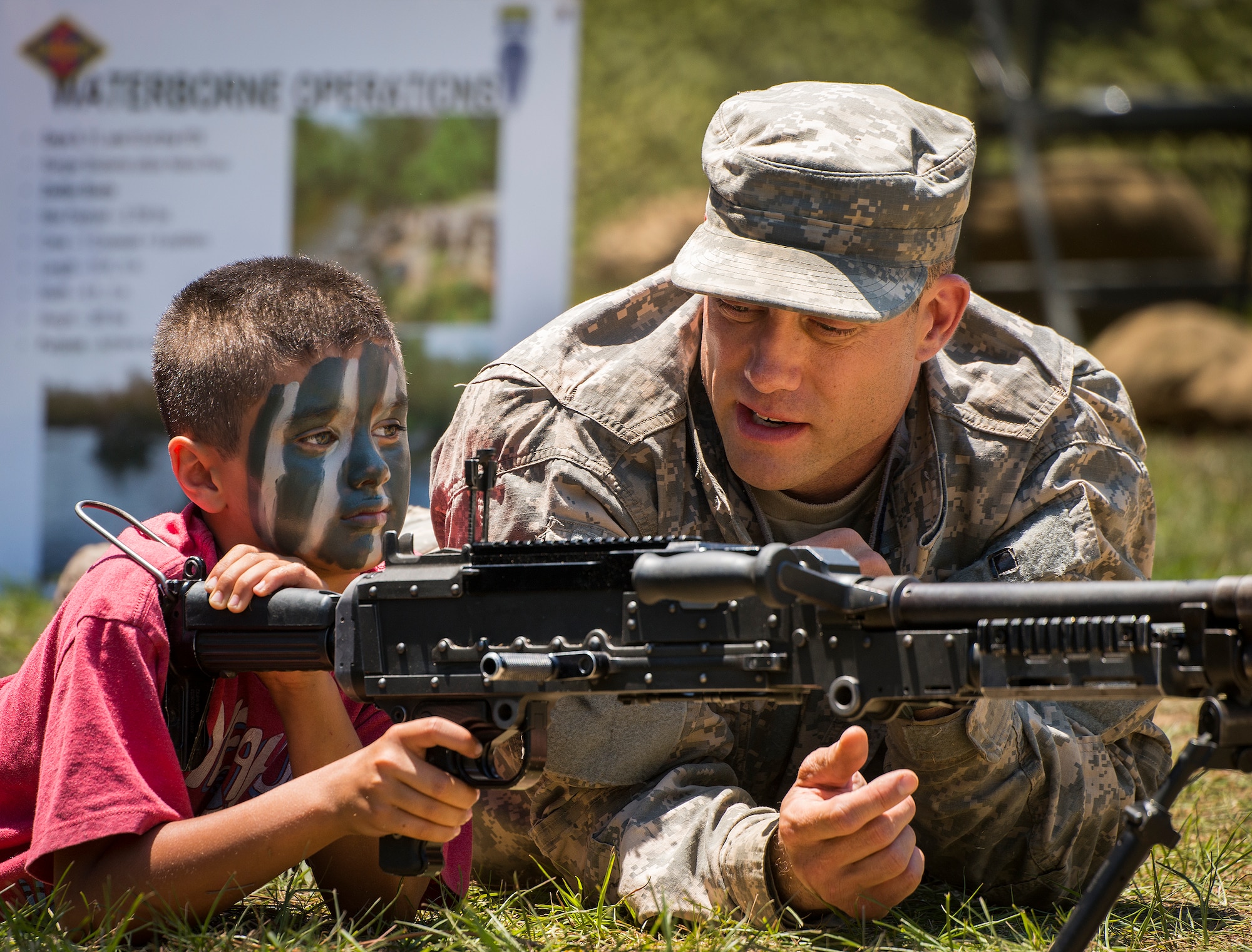 A Soldier talks with a “future Ranger” about a machine gun during the 6th Ranger Training Battalion’s open house event May 7 at Eglin Air Force Base, Fla.  The event was a chance for the public to learn how Rangers train and operate. The event displays showed equipment, weapons, a reptile zoo, face painting and weapon firing among others. The demonstrations showed off hand-to-hand combat, a parachute jump, snake show, and Rangers in action. (U.S. Air Force photo/Samuel King Jr.)