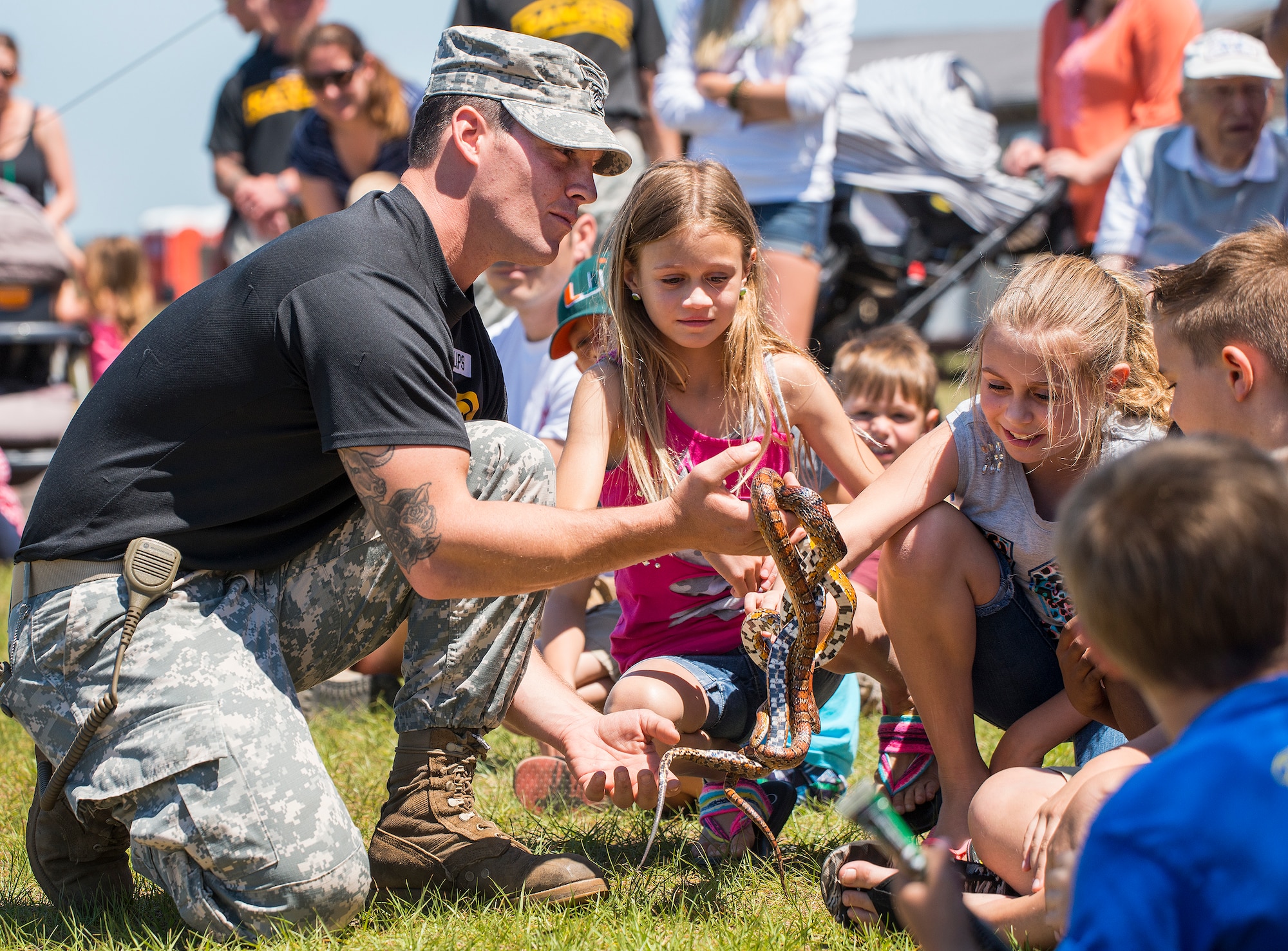 A Soldier holds snakes for children to pet during the 6th Ranger Training Battalion’s open house event May 7 at Eglin Air Force Base, Fla.  The event was a chance for the public to learn how Rangers train and operate. The event displays showed equipment, weapons, a reptile zoo, face painting and weapon firing among others. The demonstrations showed off hand-to-hand combat, a parachute jump, snake show, and Rangers in action. (U.S. Air Force photo/Samuel King Jr.)