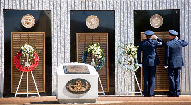 Chief Master Sgt. Martin Cortez and Maj. Emil Rebik salute the Air Force list of lost explosive ordnance disposal technicians during the 47th Annual EOD Memorial Service at the Kauffman EOD Training Complex at Eglin Air Force Base, Fla., May 7. Names of recent fallen and past EOD technicians are added to the memorial wall during the ceremony each year.  The Army, Marines and Navy added six new names this year. The all-service total now stands at 320. (U.S. Air Force photo/ Samuel King Jr.)