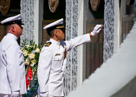 Lt. Cmdr. Sean Kiddo, unveils a new name at the 47th Annual Explosive Ordnance Disposal Memorial Service at the Kauffman EOD Training Complex at Eglin Air Force Base, Fla., May 7. Names of recent fallen and past EOD technicians are added to the memorial wall during the ceremony each year.  The Army, Marines and Navy added six new names this year. The all-service total now stands at 320. (U.S. Air Force photo/ Samuel King Jr.)