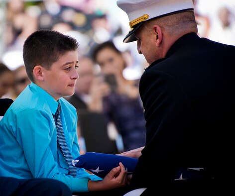 Ethen Lyon, son of fallen Marine explosive ordnance disposal technician, Staff Sgt. David Lyon, receives a folded flag at 47th Annual EOD Memorial Service at the Kauffman EOD Training Complex at Eglin Air Force Base, Fla., May 7. Lyon, who suffered wounds while deployed to Afghanistan, was one of six names of recent and past fallen EOD technicians added to the memorial wall this year.  The all-service total now stands at 320. (U.S. Air Force photo/Samuel King Jr.)