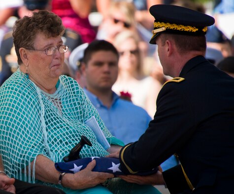 Beverly Van Alst, sister of Pvt. Clinton Mullenix, receives a folded flag from Brig. Gen. Kurt Ryan, commandant of the Army Ordnance School, during the 47th Annual EOD Memorial Service at the Kauffman EOD Training Complex at Eglin Air Force Base, Fla., May 7. Mullenix, who died in World War II, was one of six names of recent and past fallen EOD technicians added to the memorial wall this year.  The all-service total now stands at 320. (U.S. Air Force photo/ Samuel King Jr.)