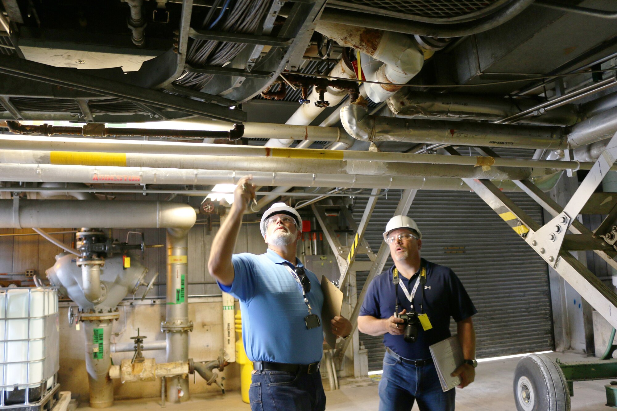 Jeffrey Vincoli (left) and Kevin Gokmer with the National Aerospace Solutions transition team, visit the von Karman Gas Dynamics Test Facility and other AEDC facilities as part of a procedure called a walk-through April 28, 2016. The procedure provides the opportunity for NAS transition team members to assess the maintenance status of each building prior to the transfer of operations. NAS will begin operating the Test Operations and Sustainment contract at AEDC July 1, 2016. (U.S. Air Force photo/Holly Peterson)