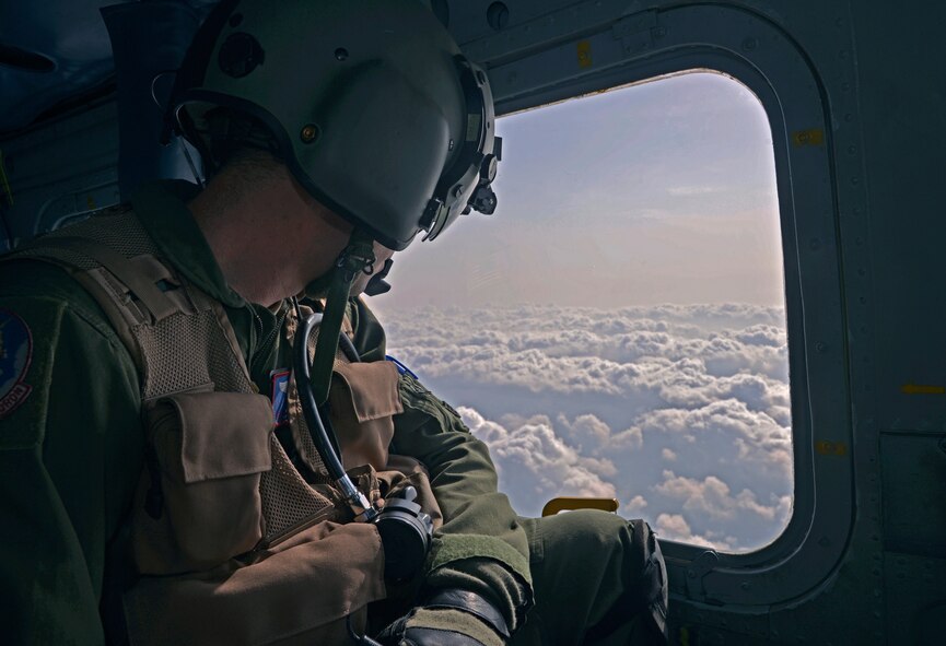 Staff Sgt. Nicholas Poe, 459th Airlift Squadron special missions aviator, looks out the window of a UH-1N Huey to check for other aircraft on the way to Marine Corps Air Station Iwakuni, Japan, May 3, 2016. Huey crew members consistently look for other aircraft flying in their vicinity to prevent flight interruptions and ensure a safe flight. (U.S. Air Force photo by Senior Airman David Owsianka/Released)