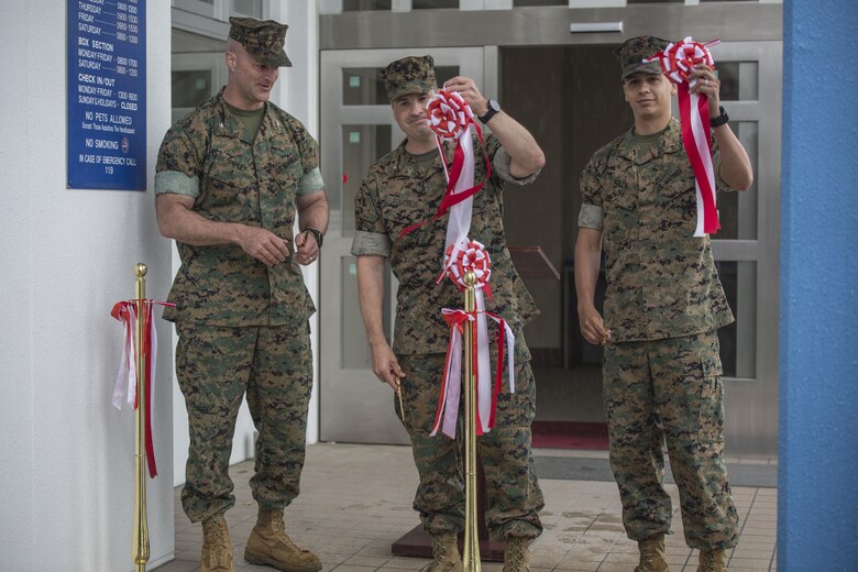 From left to right, Col. Daniel Shipley, commanding officer of Marine Aircraft Group 12, Col. Robert V. Boucher, commanding officer of Marine Corps Air Station Iwakuni, and Chief Warrant Officer Jonathan Solla, postal officer with Headquarters and Headquarters Squadron, conduct the grand opening ceremony for the new south side post office on MCAS Iwakuni, Japan, May 9, 2016. The new post office will start delivering and sending mail on opening day. (U.S. Marine Corps photo by Cpl. Nathan Wicks/Released) 