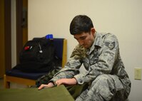 Senior Airman Maximilian Wyckoff, 51st Munitions Squadron precision guidance crew chief, secures the corner of a cot inside temporary living quarters, May 9, 2016, at Osan Air Base, Republic of Korea. Airmen from around the base temporarily relocated to buildings with built in chemical protection systems during Exercise Beverly Herd 16-01. (U.S. Air Force photo by Senior Airman Victor J. Caputo/Released)