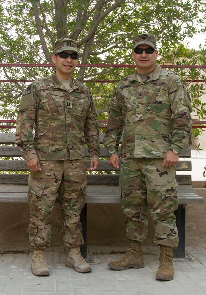 Capt. Christopher De La Pena, the U.S. Air Forces Central Command Lessons Learned Directorate deputy director, and Army Sgt. Nicholas De La Pena, a public affairs broadcast journalist with the AFCENT Public Affairs, stand together at Al Udeid Air Base, Qatar, March 18, 2016. The brothers are stationed at the same deployed location for a second time in their careers. (U.S. Army photo/Spc. Travis Terreo)