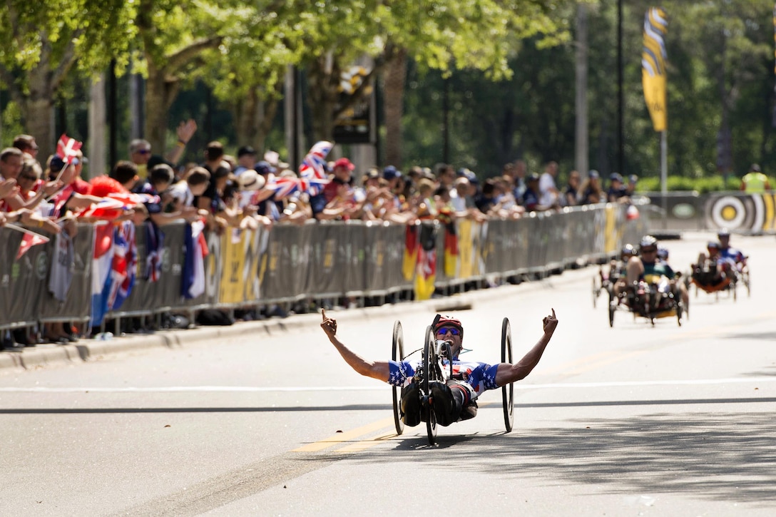 Air Force veteran Ryan Pinney celebrates after winning the gold medal in his cycling class during the 2016 Invictus Games in Orlando, Fla., May 9, 2016. DoD photo by Roger Wollenberg