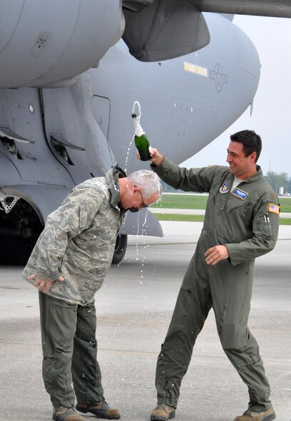 Col. Jeffrey McGalliard, 445th Airlift Wing commander, is doused with champagne by Maj. Eric Palichat, 89th Airlift Squadron C-17 pilot, following his fini flight May 5, 2016. McGalliard arrived at the 445th AW November 2013 and will retire in June. The 445th Airlift Wing change of command is May15. (U.S. Air Force photo/Stacy Vaughn)