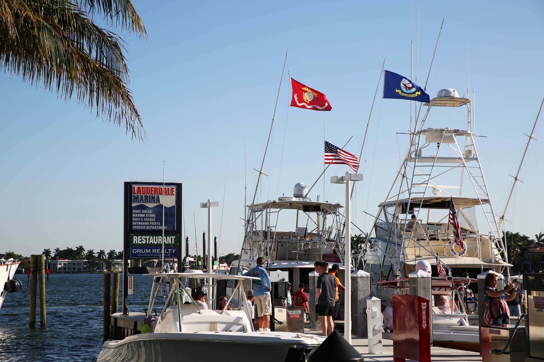 The Fort Lauderdale Marina flies the American, Navy, and Marine Corps flag over their docks during the Take a Hero Fishing event as part of Fleet Week Port Everglades, Fort Lauderdale, Fla., May 5, 2016. The Take a Hero Fishing event gave Marines and Sailors the opportunity to spend the day off the Florida coast with local sport fisherman and boat owners while engaging in some friendly competition to see who can catch the biggest fish. (U.S. Marine Corps photo by Lance Cpl. Brianna Gaudi/Released.)