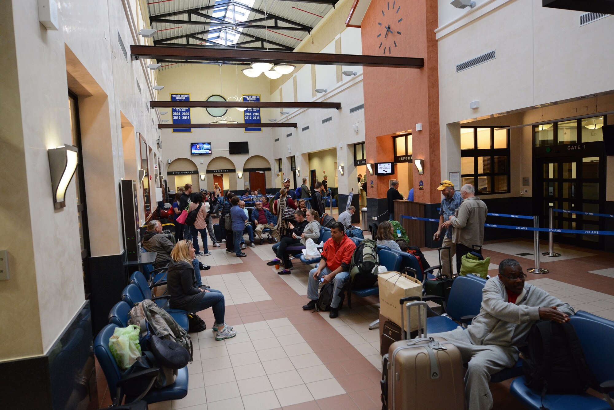 Civilian and military travelers at the 724th Air Mobility Squadron's passenger terminal wait for an aircraft boarding announcement May 6, 2016, at Aviano Air Base, Italy. Reservists from the 71st Aerial Port squadron located at Joint Base Langley-Eustis, Va., traveled to Italy to gain hands-on experience in multiple sections of aerial port operations by working with active-duty Airmen from the 724th AMS, whose air transportation facility earned eight Small Terminal of the Year awards since 2004. (U.S. Air Force photo/Staff Sgt. Joe Yanik)