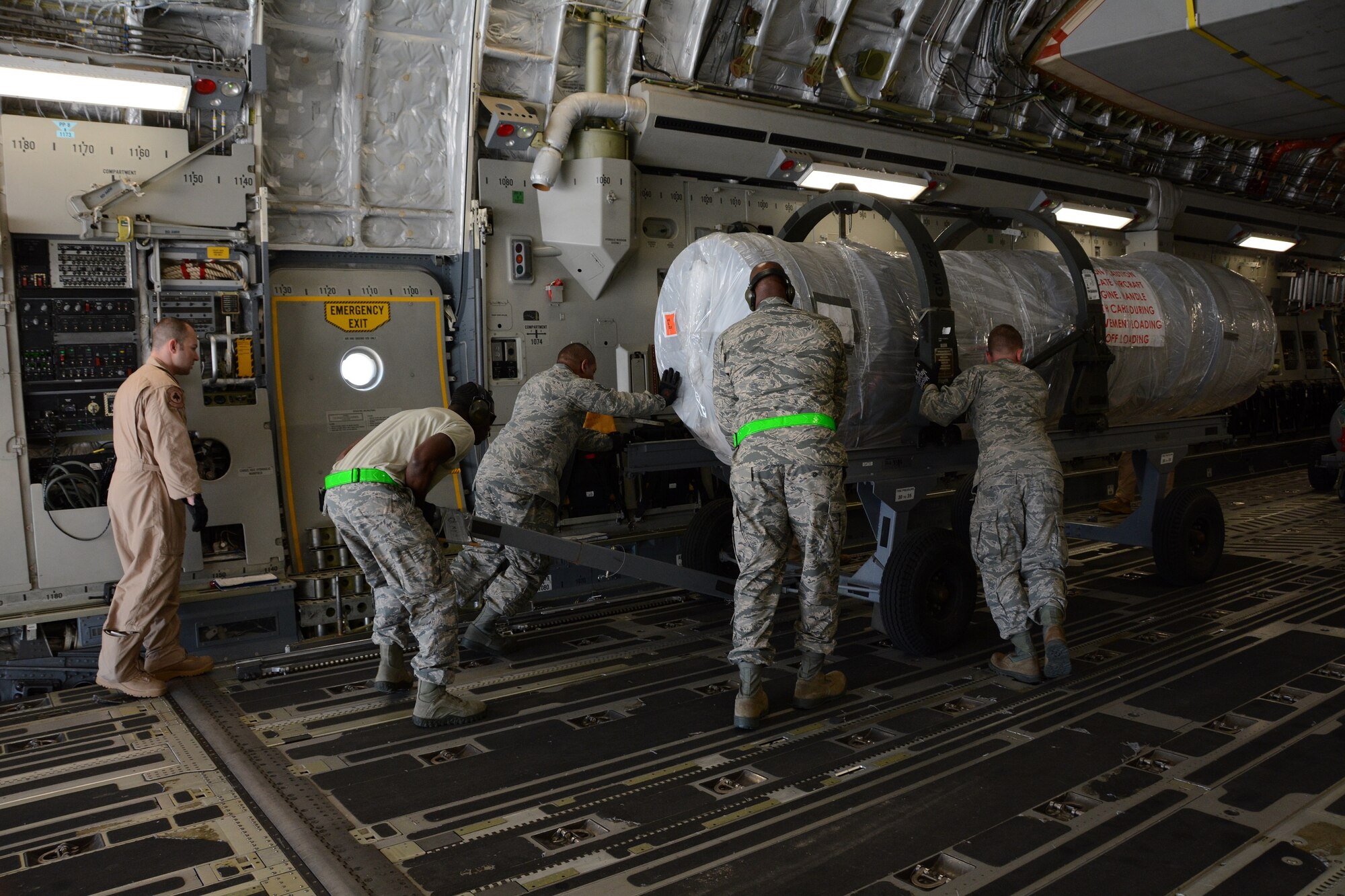 Reservists from the 71st Aerial Port Squadron, based out of Joint Base Langley-Eustis, Va., gain hands-on experience with processing, inspecting and ensuring air worthiness of cargo during their two-week annual tour at Aviano Air Base, Italy, May 6, 2016. 71st APS Airmen guide an aircraft engine with active-duty Airmen from the 724th Air Mobility Squadron aboard a C-17 Globemaster III May 6, 2016. (U.S. Air Force photo/Tech. Sgt. Mercedes Crossland) 