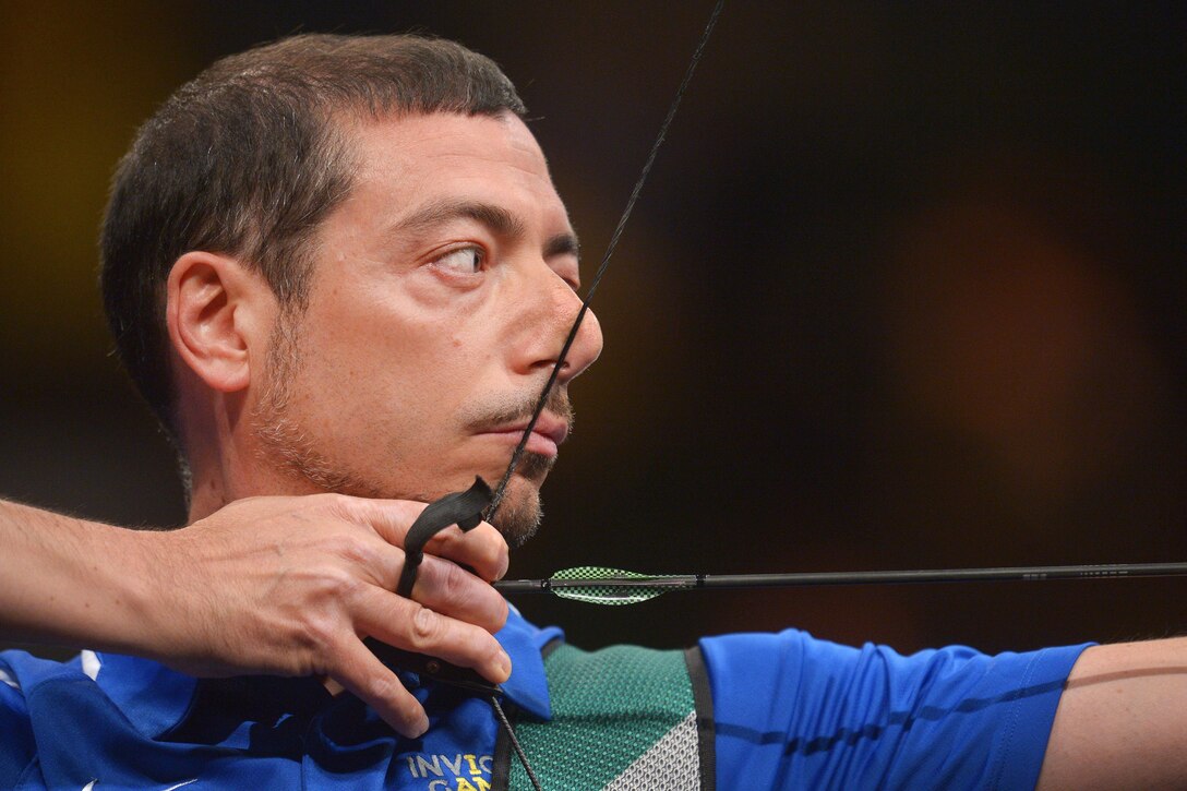 Fabio Tomasulo, a member of the Italian team, draws back and prepares to release an arrowing as he competes in the archery finals during the 2016 Invictus Games in Orlando, Fla., May 9, 2016. Army photo by Staff Sgt. Alex Manne