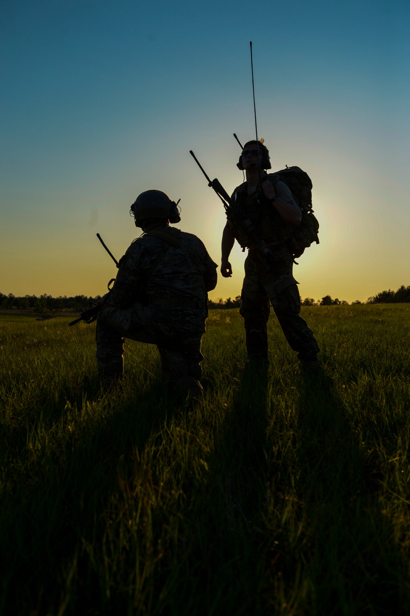 A U.S. Air Force Special Tactics Airman assigned to the 24th Special Operations Wing pulls security while another Special Tactics Airman radios an incoming aircraft during Emerald Warrior 16 at Camp Shelby Joint Forces Training Center, Miss., May 7, 2016. Emerald Warrior is a U.S. Special Operations Command-sponsored mission rehearsal exercise during which joint special operations forces train to respond to real and emerging worldwide threats. (U.S. Air Force photo by Senior Airman Colville McFee)