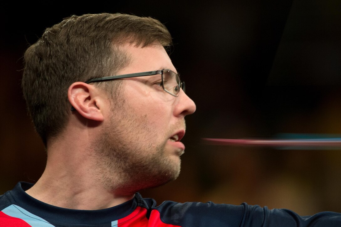 An arrow creates a streak as Great Britain’s Martin Clapton releases the arrow from his mouth during an archery round for the bronze medal during the 2016 Invictus Games in Orlando, Fla., May 9, 2016. DoD photo by EJ Hersom